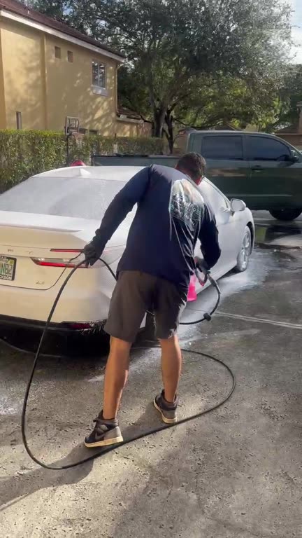 Foam cannon covering a white sedan